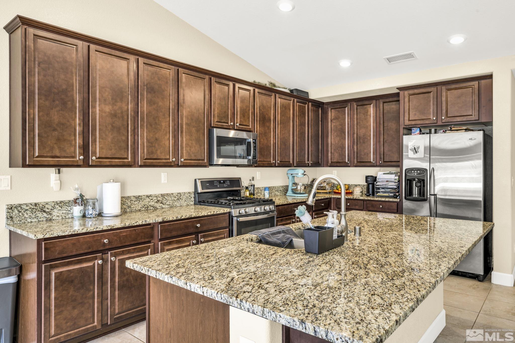 6508 Copper Mountain Drive Carson City, NV 89701 - Photo 5 of 40 a kitchen with kitchen island granite countertop a sink stove and refrigerator