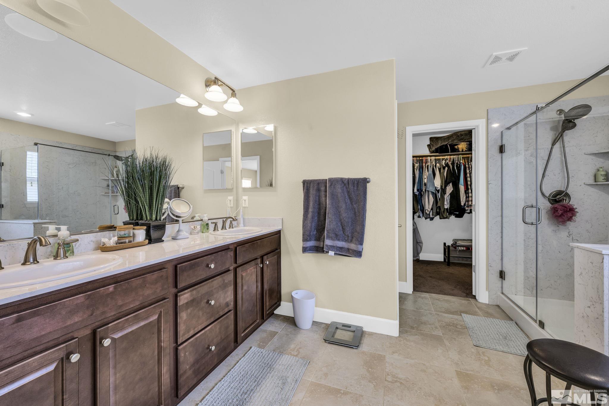 6508 Copper Mountain Drive Carson City, NV 89701 - Photo 10 of 40 a spacious bathroom with a double vanity sink a large mirror and shower