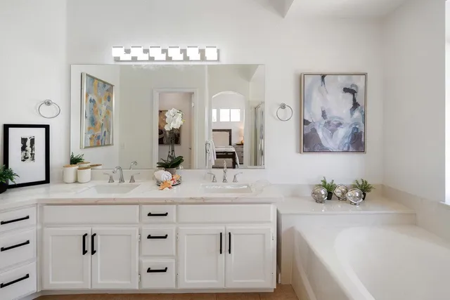 a bathroom with a tub sink and mirror