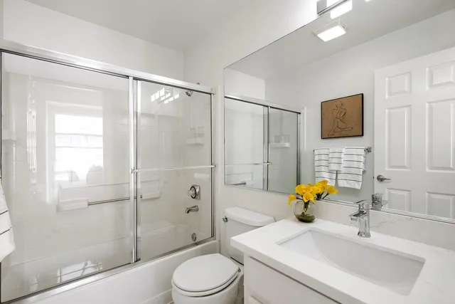 a bathroom with a sink a toilet and shower