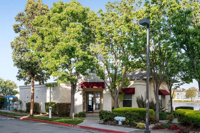 a view of a white house with table and chairs in front of it