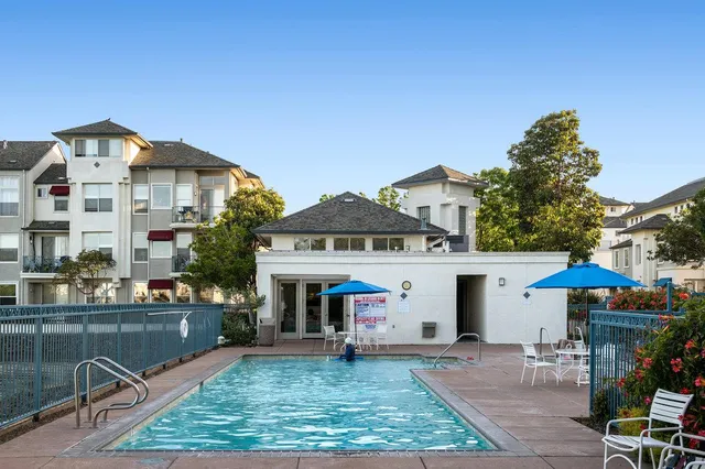 a view of a patio with a table and chairs under an umbrella with potted plants