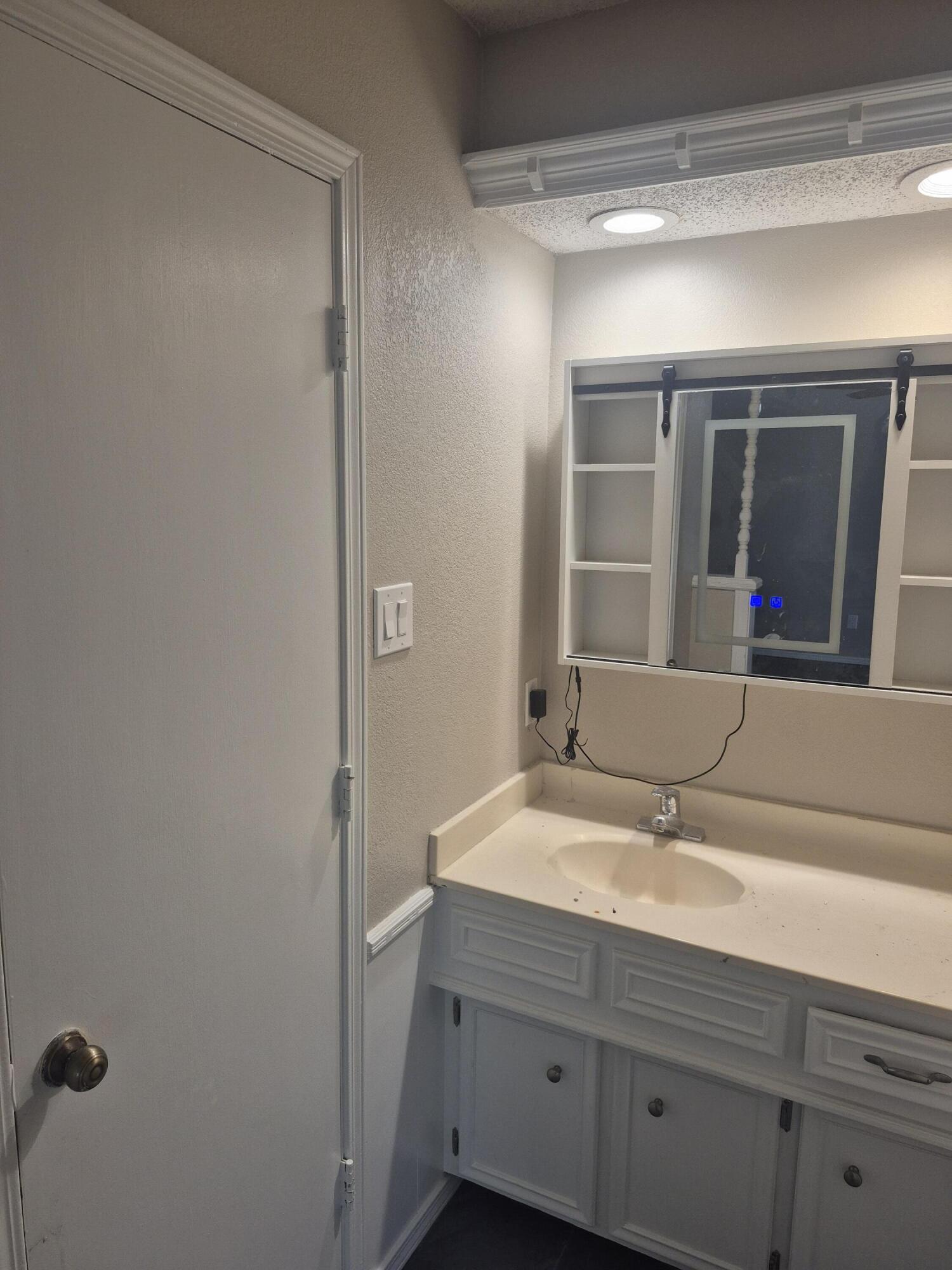 3211 94th Street Lubbock, TX 79423 - Photo 12 of 24 a bathroom with a sink and a mirror