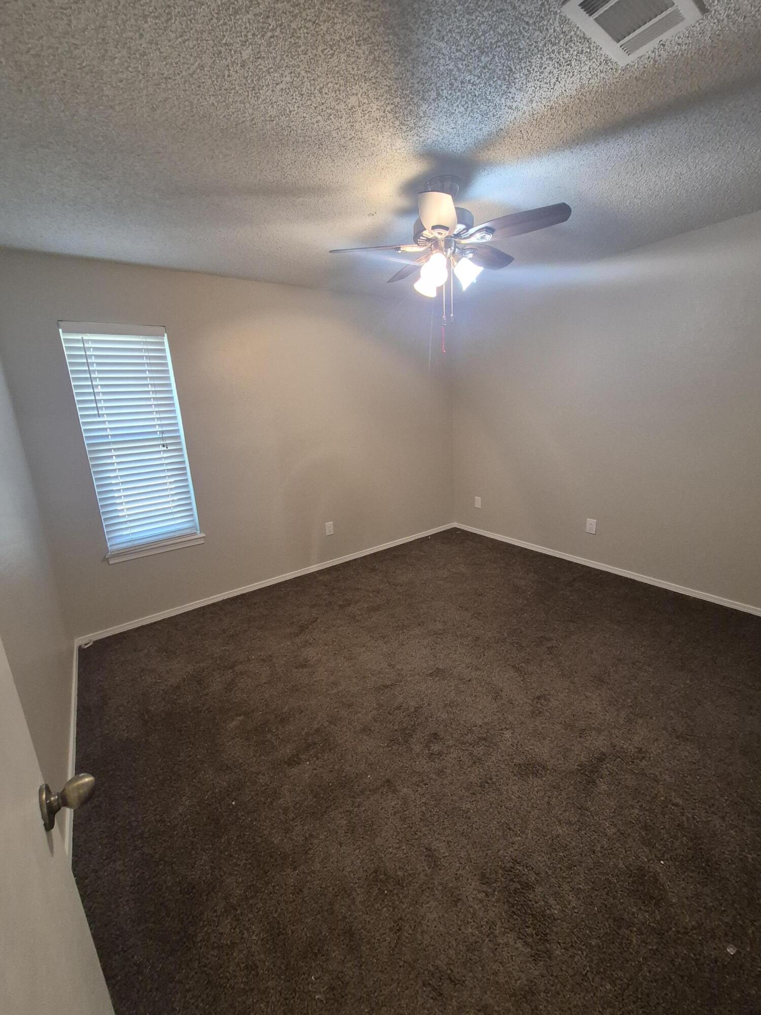 3211 94th Street Lubbock, TX 79423 - Photo 14 of 24 an empty room with windows and fan