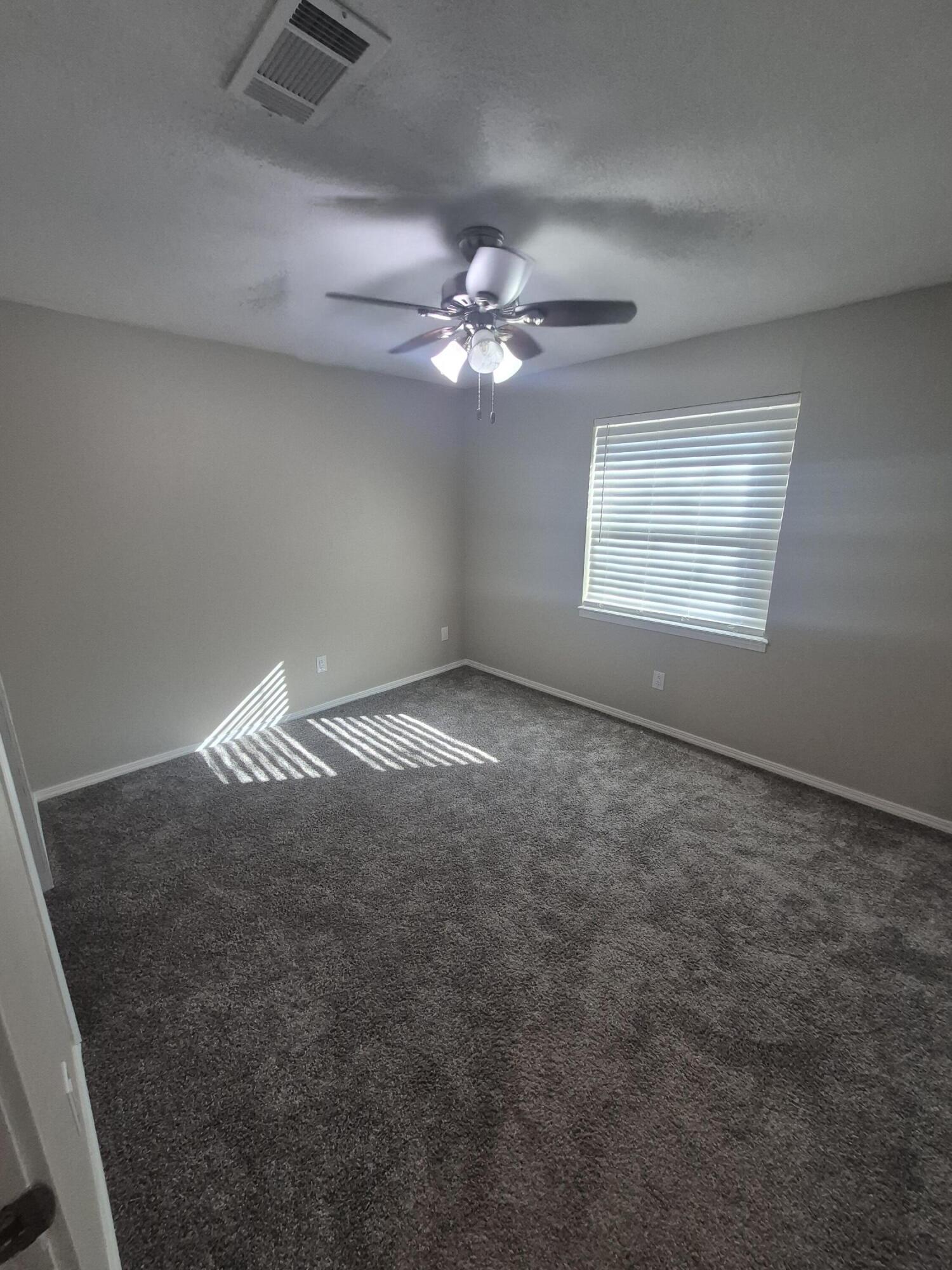 3211 94th Street Lubbock, TX 79423 - Photo 17 of 24 an empty room with windows and fan