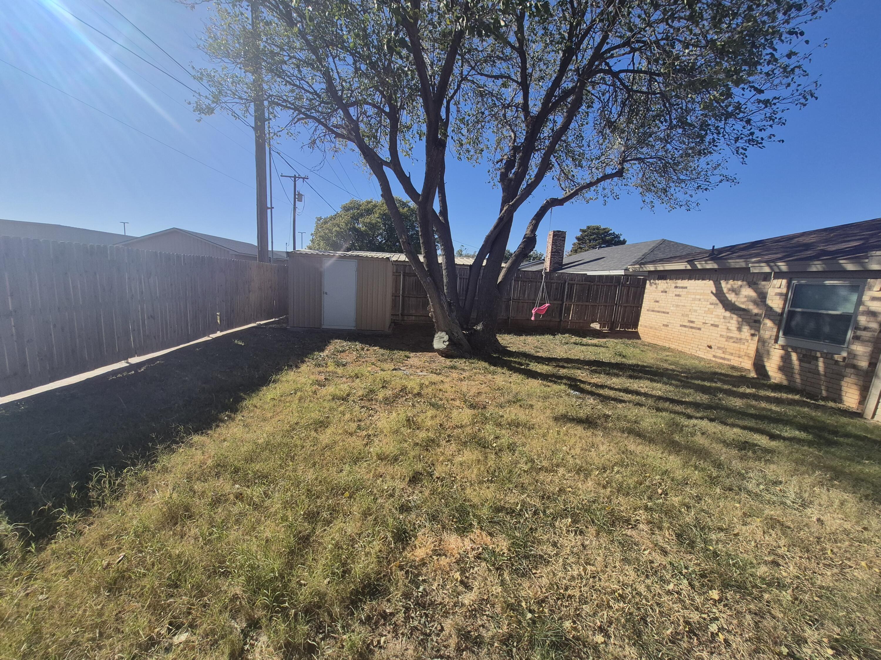 3211 94th Street Lubbock, TX 79423 - Photo 21 of 24 a view of a yard with a large tree