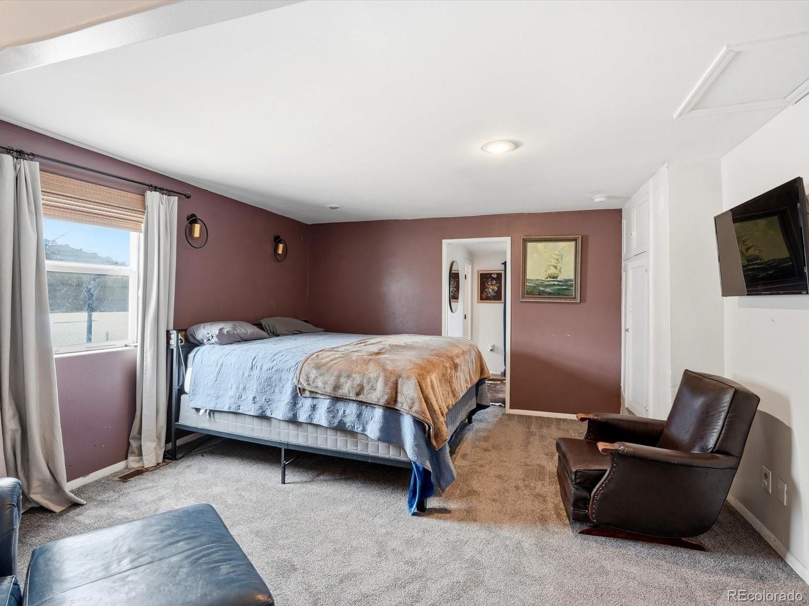 360 South 7th Avenue Brighton, CO 80601 - Photo 24 of 43 a bedroom with a bed and a flat screen tv