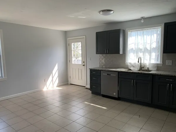 a kitchen with granite countertop a sink and a stove