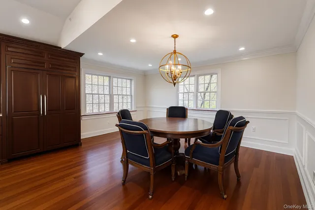 a view of a dining room with furniture a chandelier and wooden floor