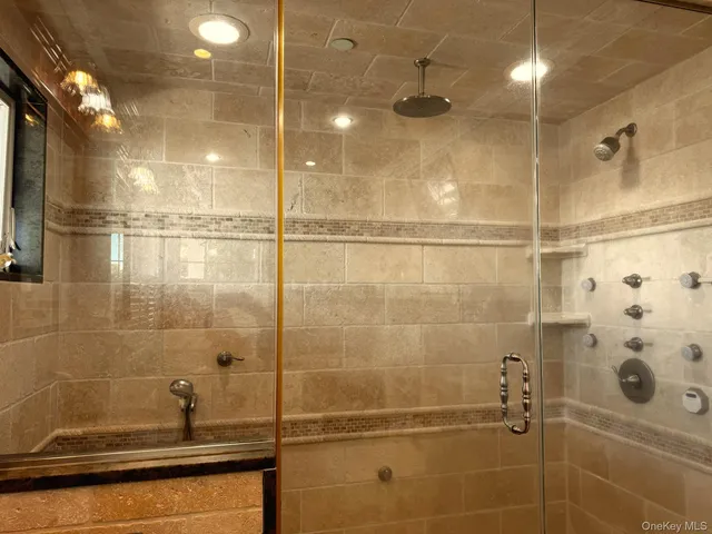 a large bed sitting in a spacious bedroom next to a window and a chair