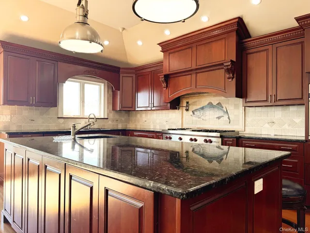 a kitchen with granite countertop a sink a counter space appliances and cabinets