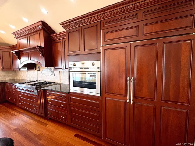 a kitchen with stainless steel appliances granite countertop wood cabinets and granite counter tops