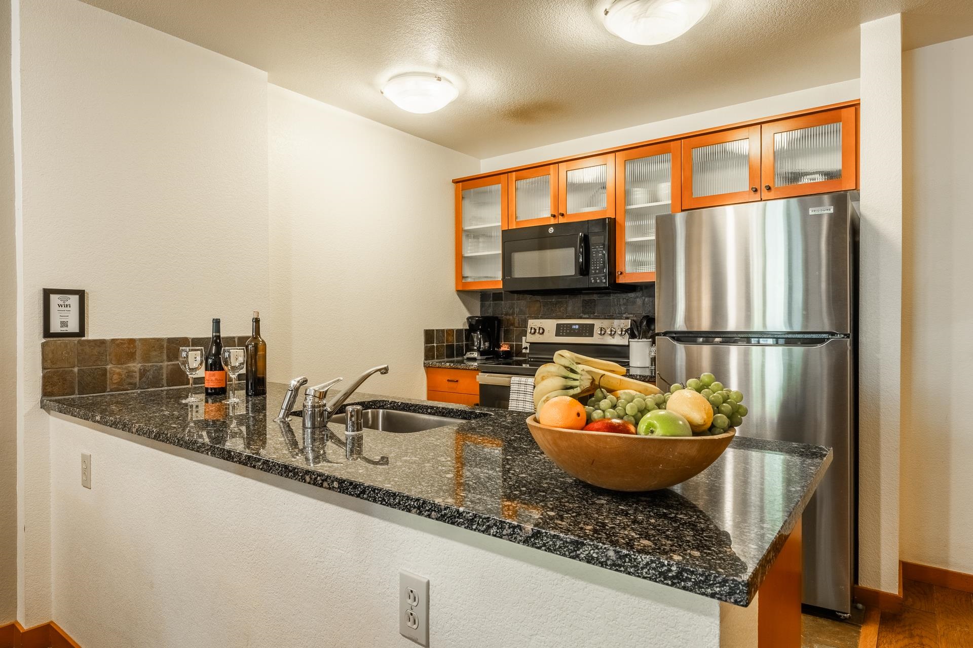 6201 Minaret Road, Unit 2220 Mammoth Lakes, CA 93546 - Photo 10 of 14 a kitchen with a stove a sink and a microwave