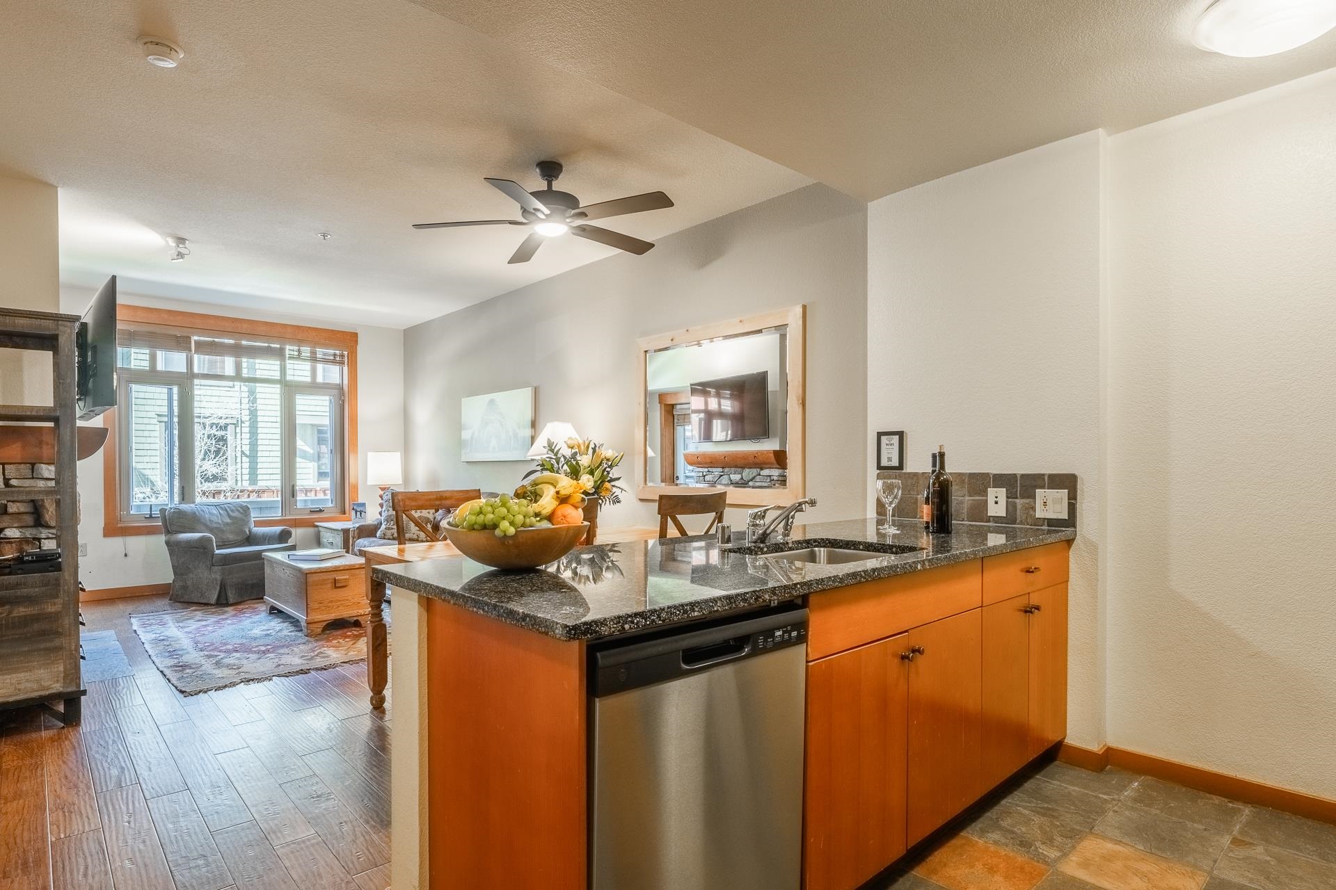 6201 Minaret Road, Unit 2220 Mammoth Lakes, CA 93546 - Photo 7 of 14 a kitchen with stainless steel appliances granite countertop a sink stove and wooden cabinets