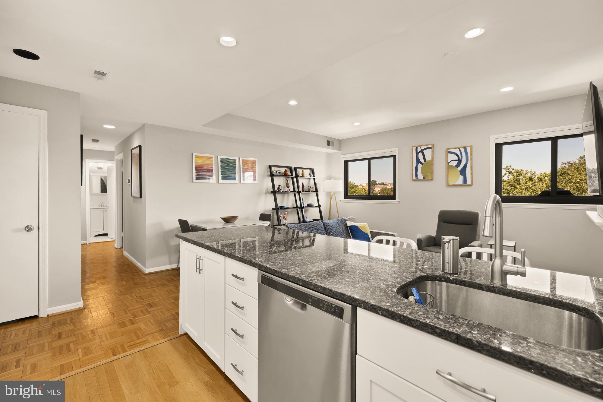 1715 15th Street Northwest, Unit 401 Washington, DC 20009 - Photo 3 of 28 a kitchen with granite countertop a sink and white cabinets