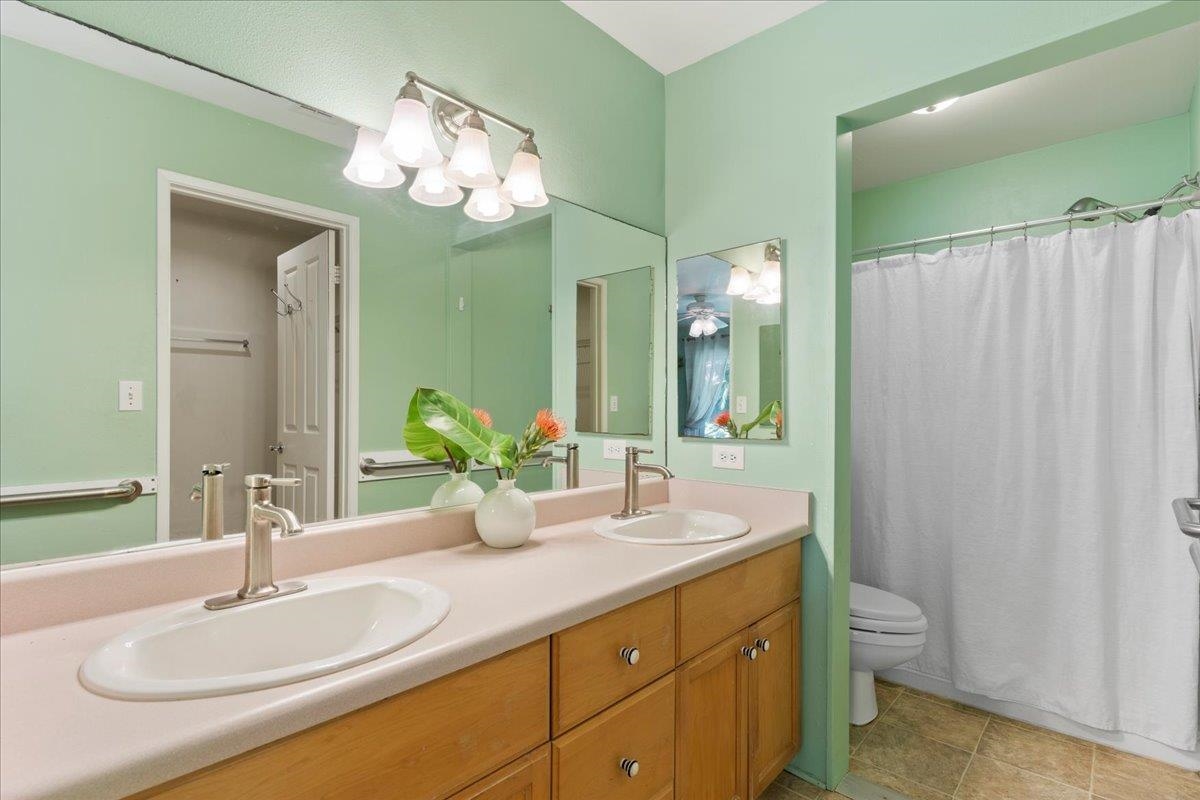 81 Lae Street Paia, HI 96779 - Photo 33 of 47 a bathroom with a granite countertop sink a toilet and a mirror