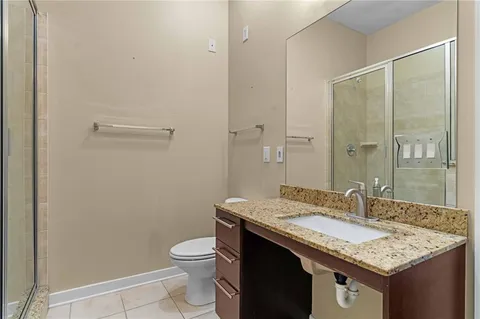 a bathroom with a granite countertop sink a toilet and shower