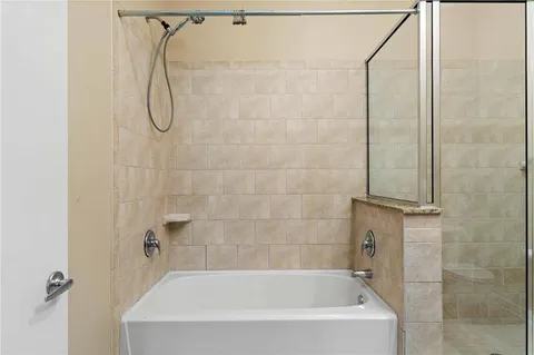 a bathroom with a bath tub with a shower