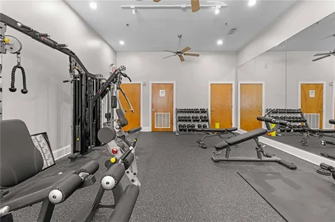 a living room with furniture gym equipment and a large window