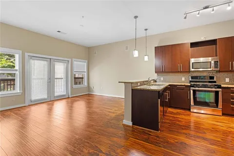 a kitchen with stainless steel appliances granite countertop a stove a refrigerator and a microwave oven