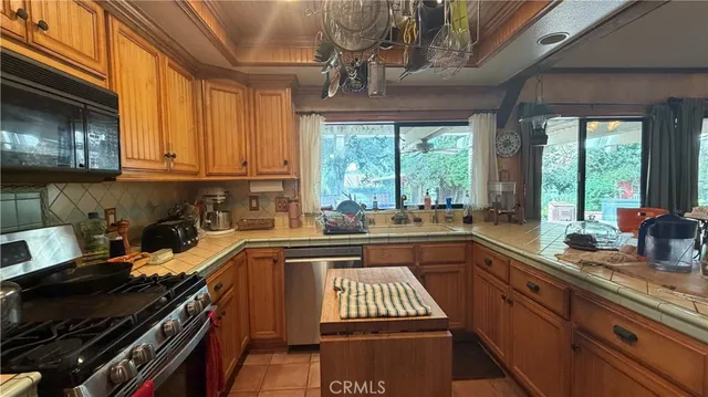 a kitchen with a sink a stove cabinets and black appliances