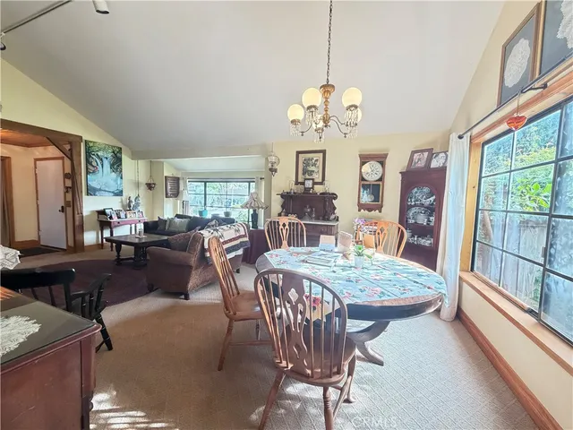 a view of a dining room with furniture a chandelier and wooden floor