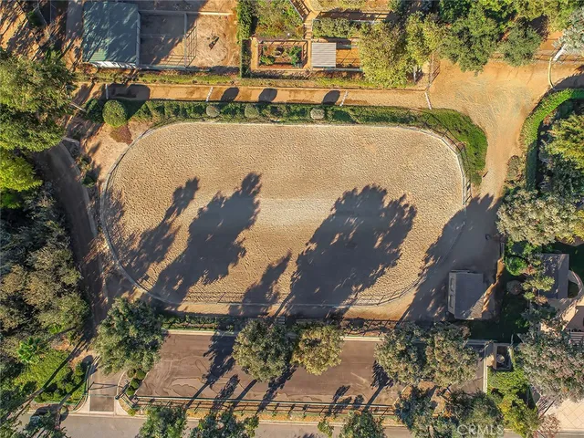 an aerial view of a house with a yard and large trees