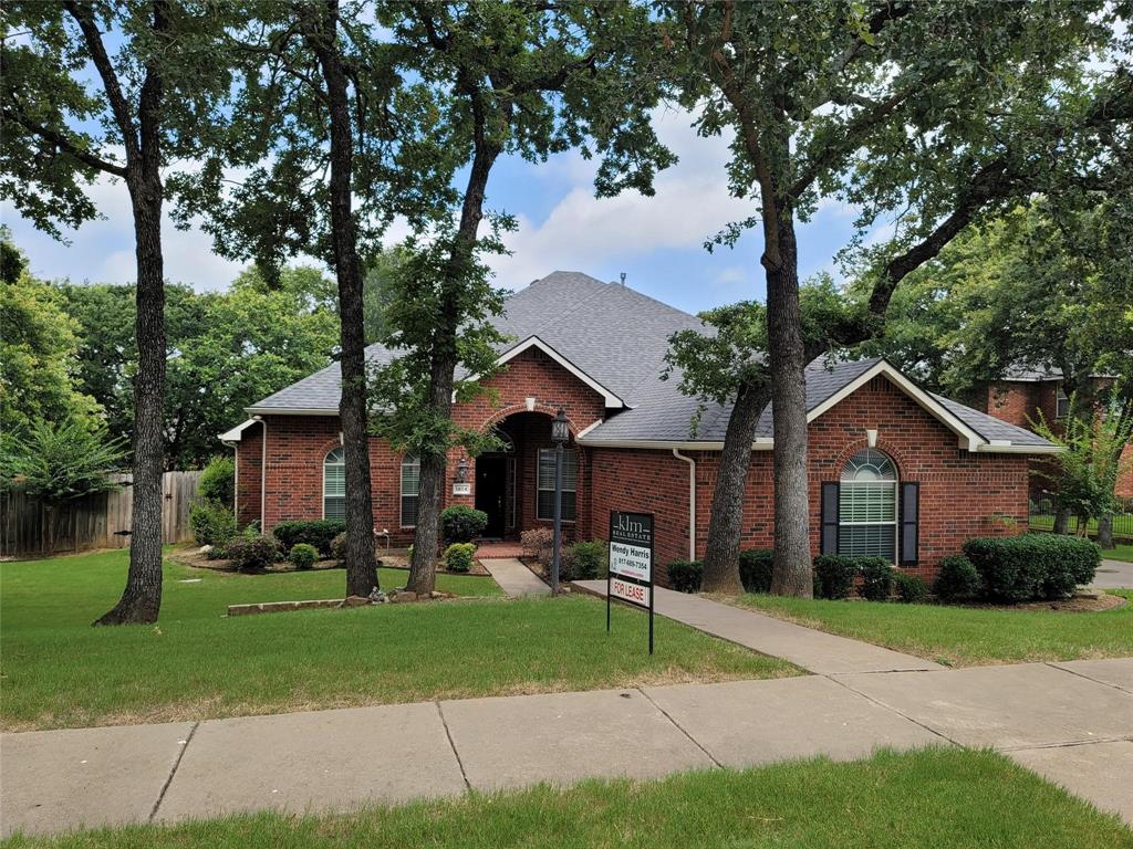 a view of a house with a yard and large tree