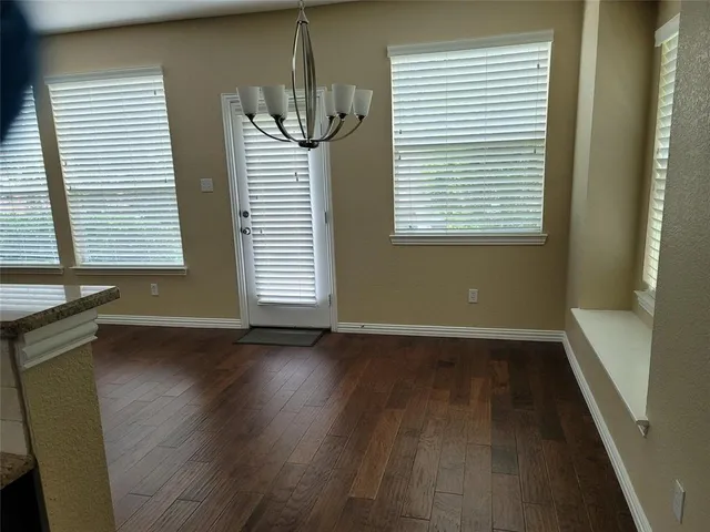 an empty room with wooden floor and a window