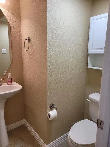 a bathroom with a sink a toilet and a mirror