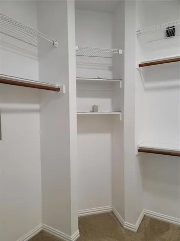 a view of walk in closet with empty racks