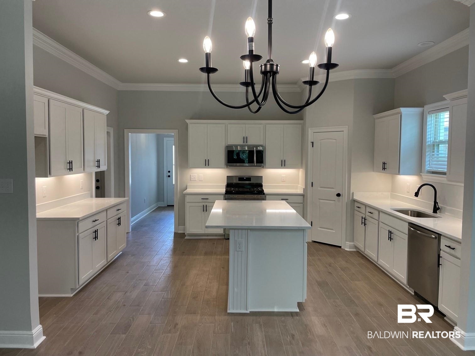 1626 Fenton Circle Foley, AL 36535 - Photo 3 of 16 Kitchen featuring white cabinetry, crown molding, light wood-type flooring, appliances with stainless steel finishes, and sink