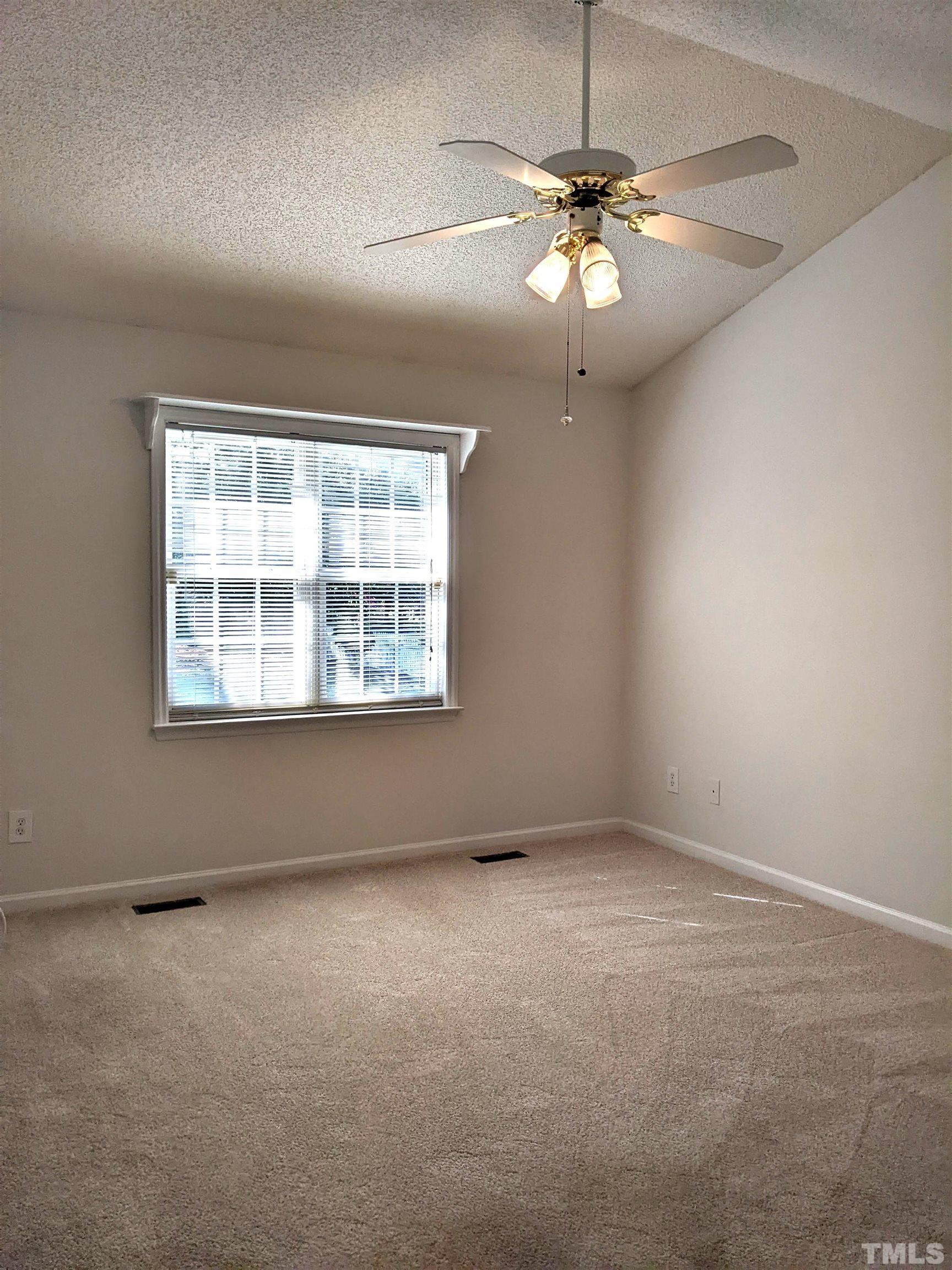 1629 Tall Cane Circle Willow Spring, NC 27592 - Photo 17 of 23 an empty room with a chandelier fan and windows