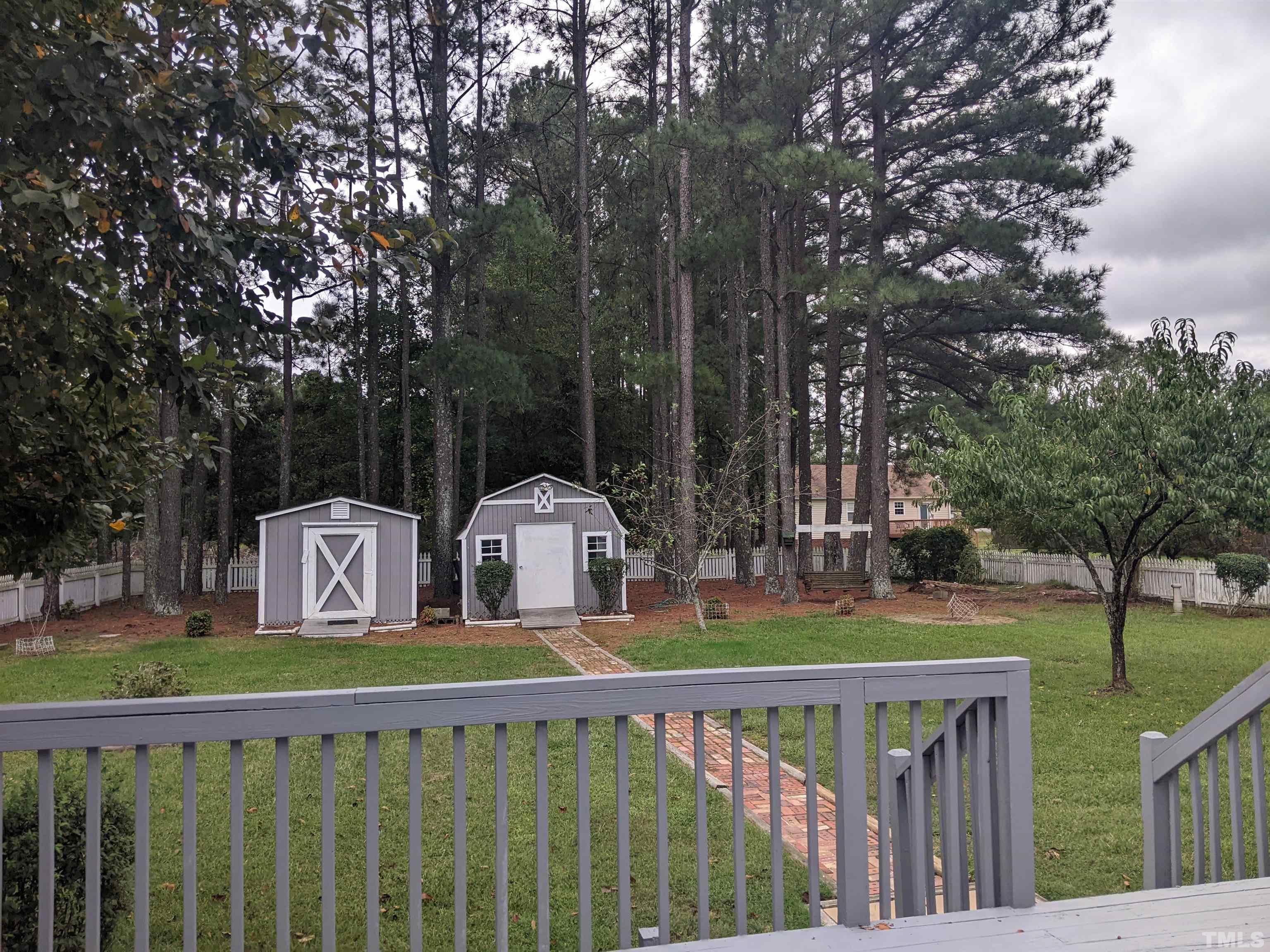 1629 Tall Cane Circle Willow Spring, NC 27592 - Photo 22 of 23 a view of a deck with large trees and wooden fence