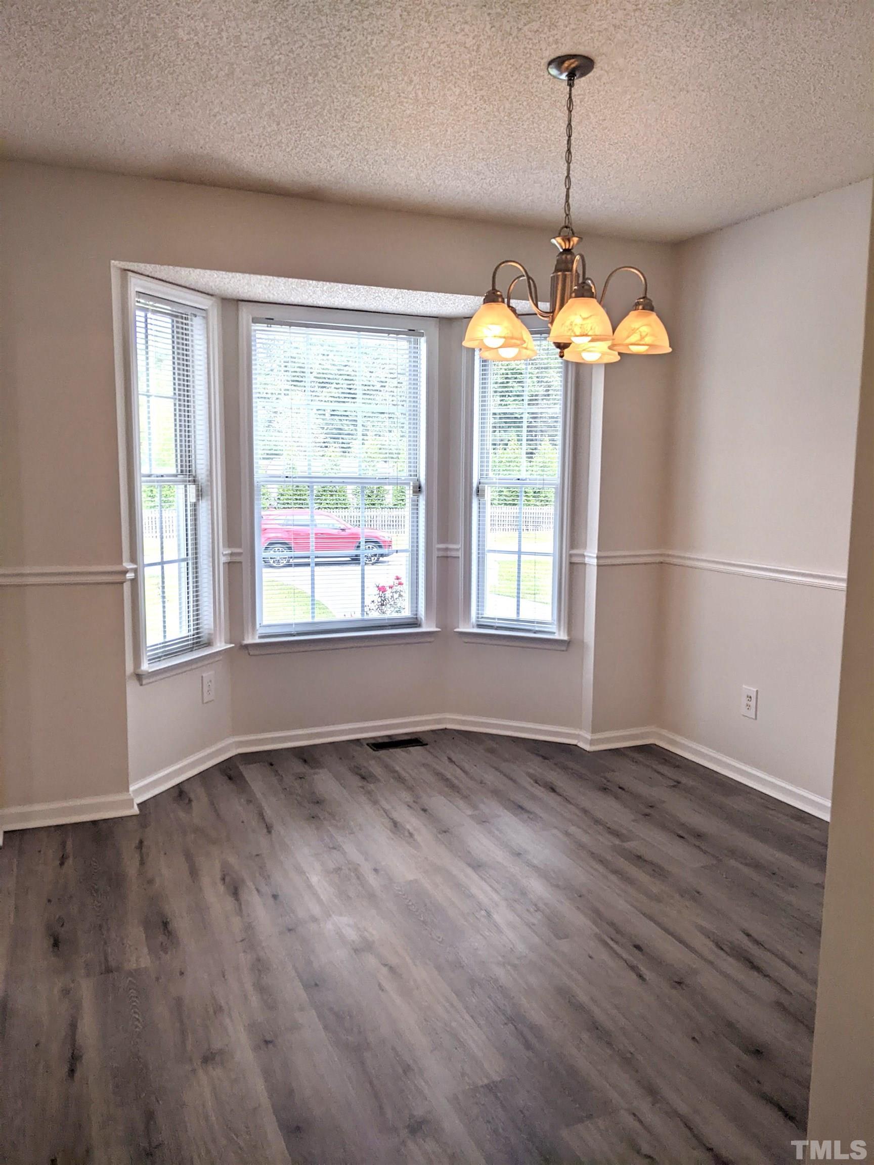 1629 Tall Cane Circle Willow Spring, NC 27592 - Photo 3 of 23 a view of an empty room with wooden floor and a window