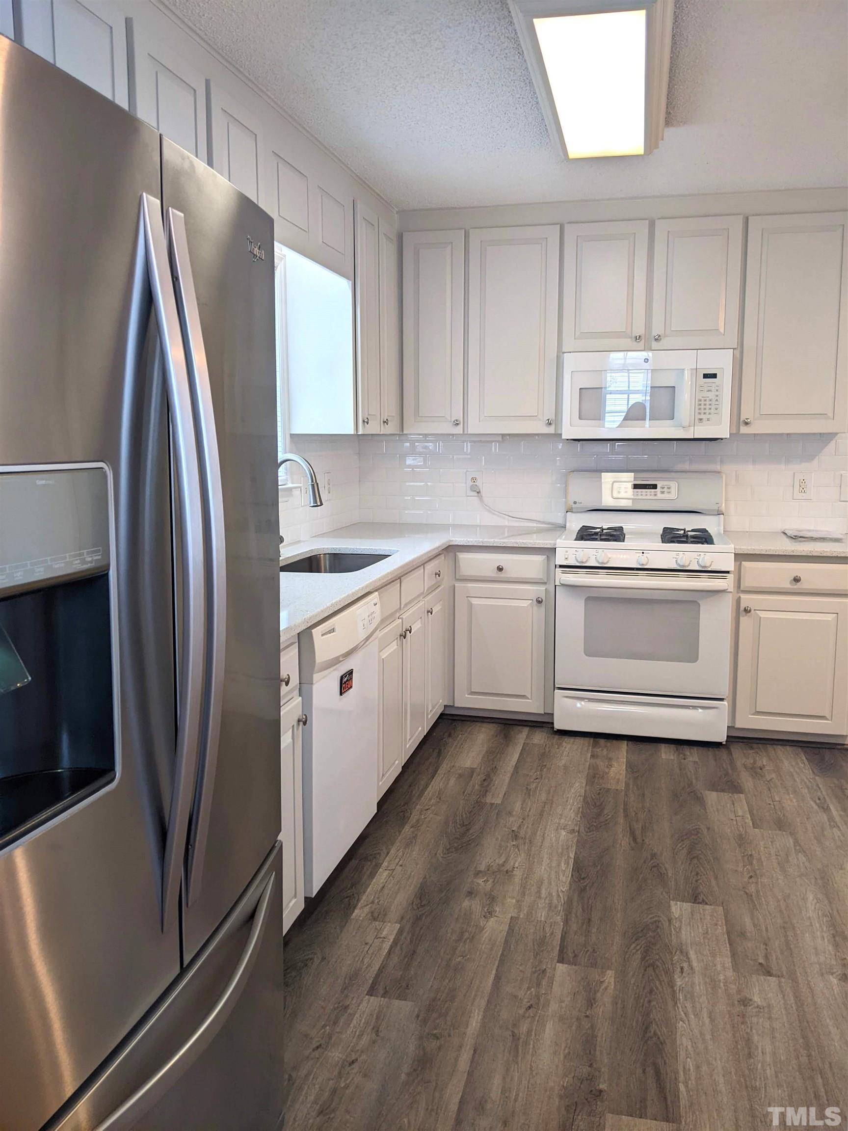 1629 Tall Cane Circle Willow Spring, NC 27592 - Photo 6 of 23 a kitchen with stainless steel appliances granite countertop a refrigerator sink and microwave