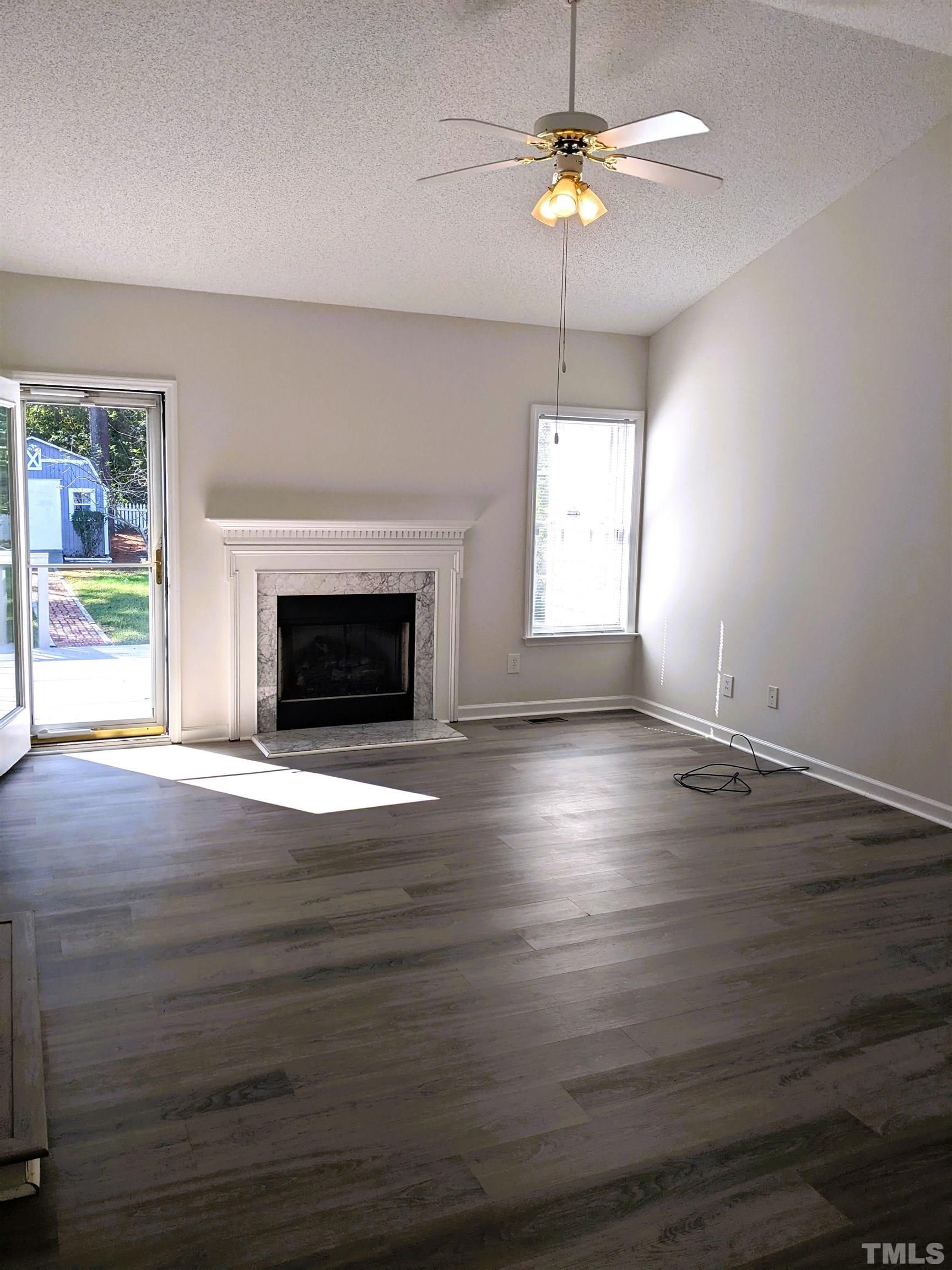 1629 Tall Cane Circle Willow Spring, NC 27592 - Photo 8 of 23 an empty room with wooden floor chandelier fan and windows