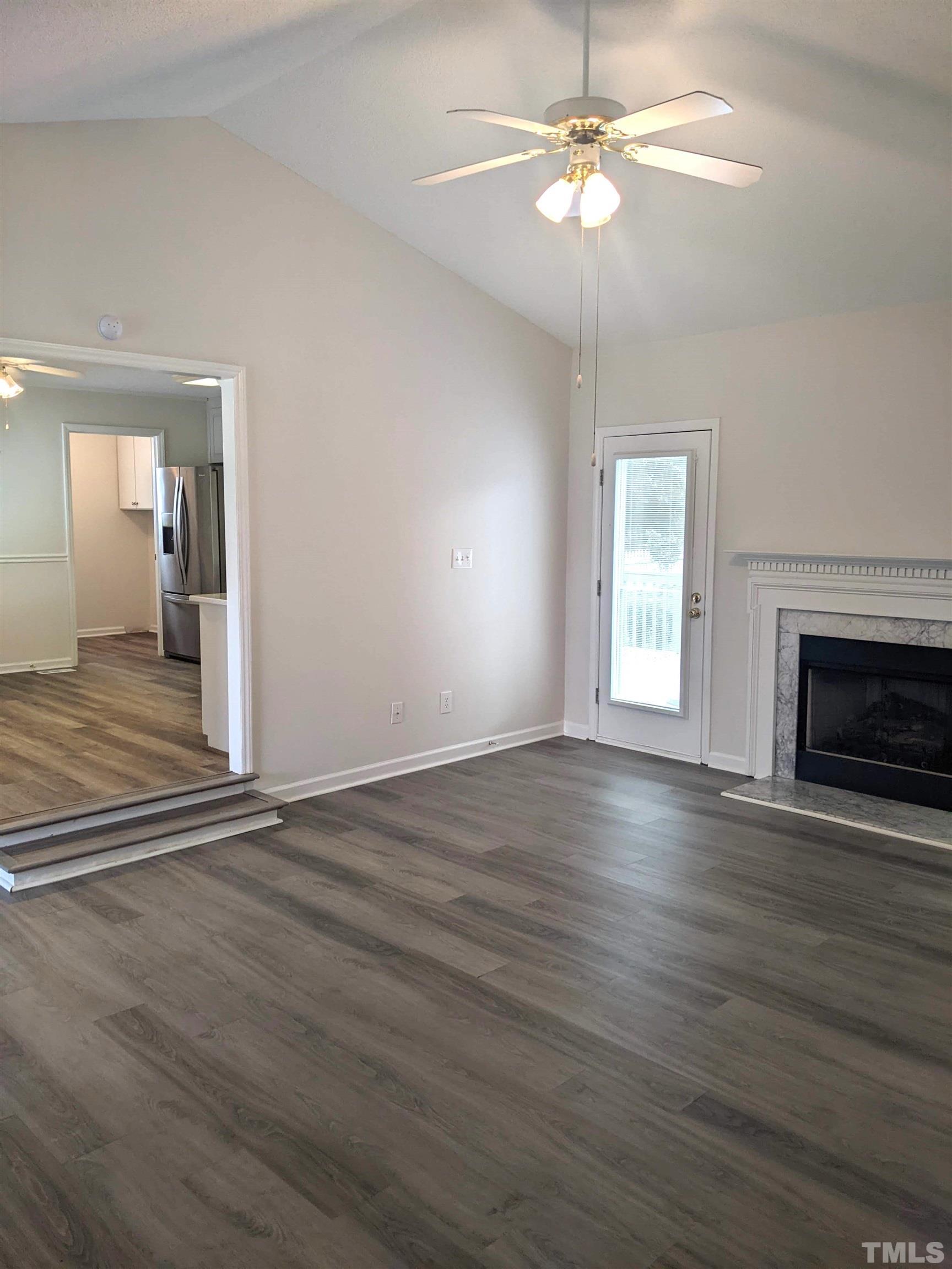 1629 Tall Cane Circle Willow Spring, NC 27592 - Photo 10 of 23 an empty room with wooden floor chandelier fan and windows