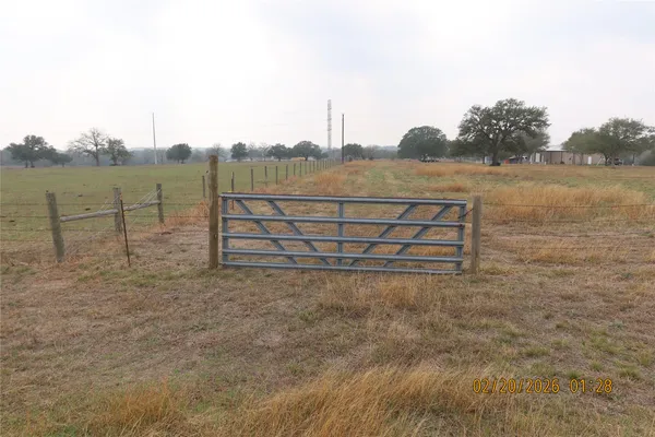 a view of a yard with wooden fence
