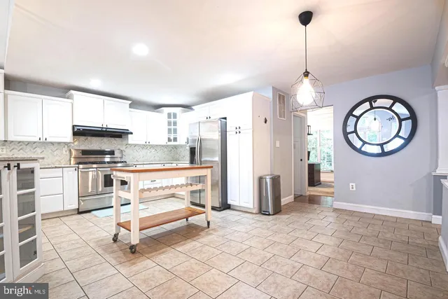 a kitchen with granite countertop a stove a refrigerator and a stove top oven