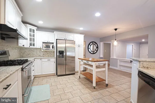 a view of an empty room with a window and a dresser