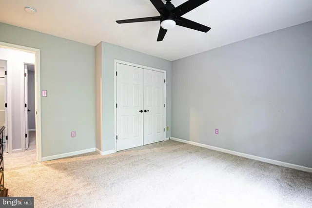 a bed sitting in a spacious bedroom next to a window