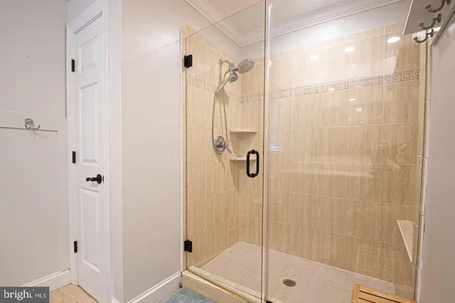 a porch with a table and chairs and potted plants next to a large window