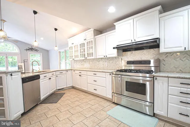 a kitchen with granite countertop white cabinets and white appliances