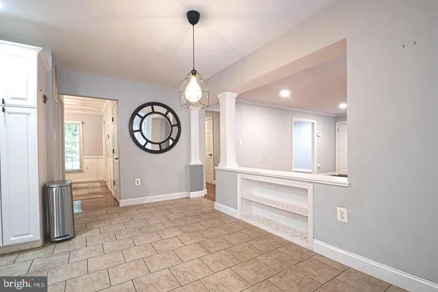 a kitchen with white cabinets and refrigerator