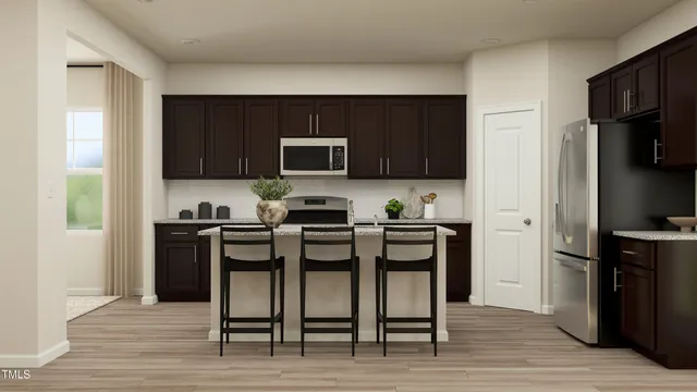 a kitchen with a sink a microwave a refrigerator and cabinets
