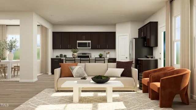 a living room with furniture a flat screen tv and kitchen view