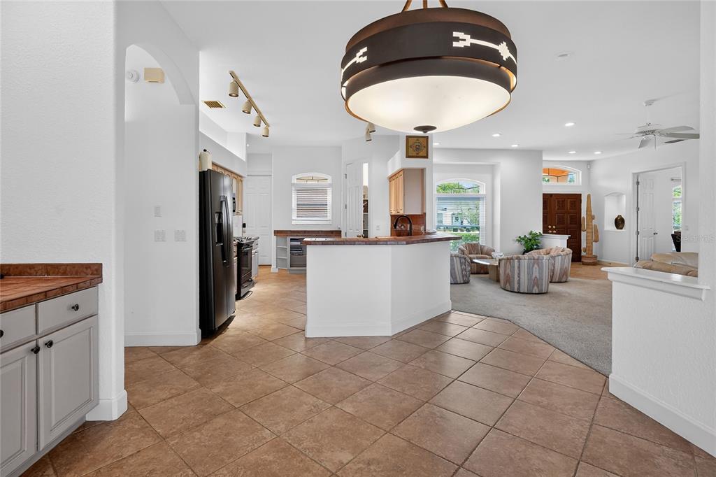 2968 Plantation Road Winter Haven, FL 33884 - Photo 18 of 81 a kitchen with stainless steel appliances kitchen island granite countertop a refrigerator a stove a sink and a dishwasher