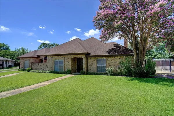 a front view of a house with yard and green space