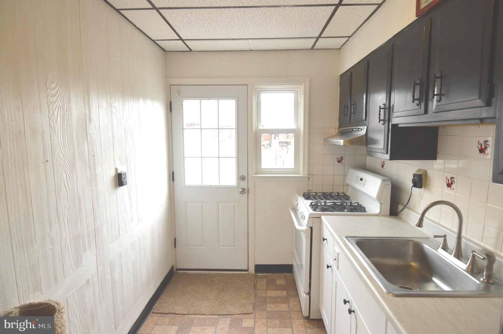 9742 Conmar Road Baltimore, MD 21220 - Photo 6 of 22 a kitchen with stainless steel appliances a sink a stove and a refrigerator with wooden cabinets
